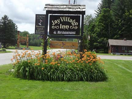 outdoor signage next to a road with the jay village logo on it