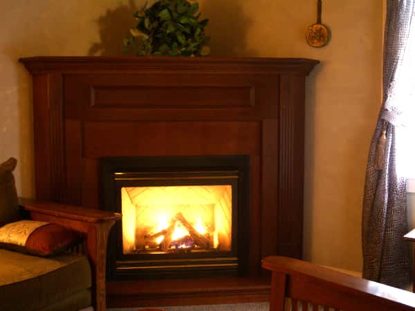 suite with the fireplace on and a chair next to it