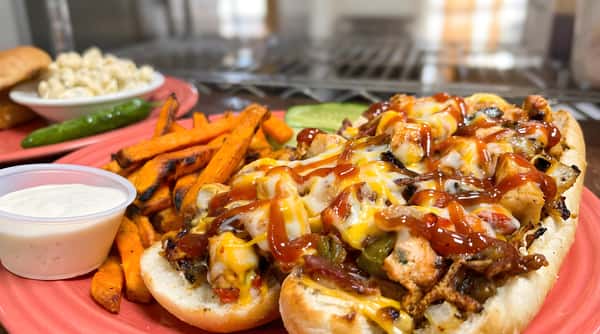 Loaded chicken sliders topped with melted cheese, bacon, and sauce with fries on the side.