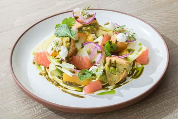 Fresh seafood salad plated with citrus, herbs, and vibrant vegetables at an upscale contemporary restaurant