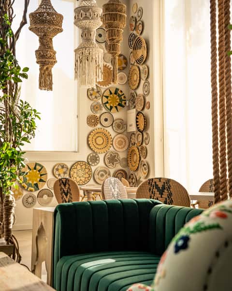 Stylish lounge seating area with decorative wall art and plush green velvet bench in a modern restaurant