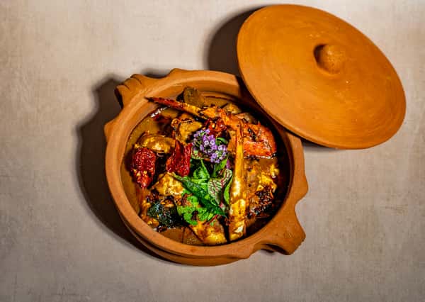 Colorful Indian curry dish served in a traditional clay pot with vibrant vegetables and rich spices
