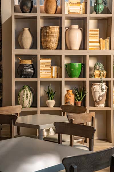 Decorative restaurant shelving with curated pottery, plants, and modern upscale interior styling