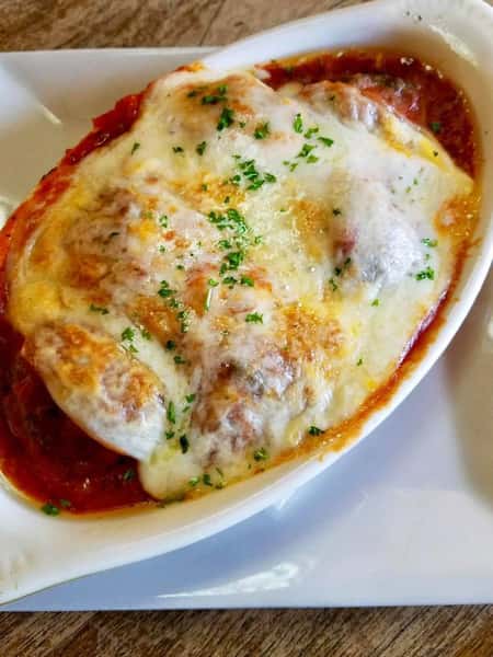 meatballs topped with melted cheese in a baking dish
