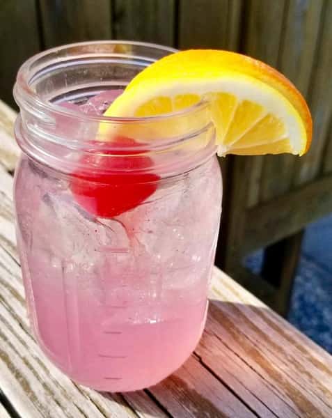cocktail in a mason jar with a lemon wedge