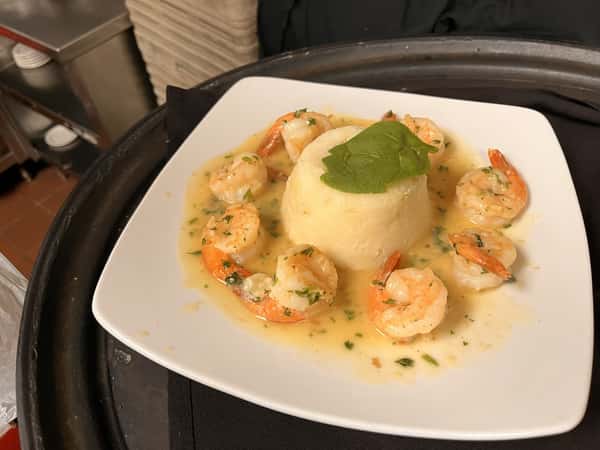 Shrimp scampi served in a creamy garlic sauce with a molded rice center