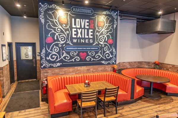 Red booth with 'Love Exile' mural