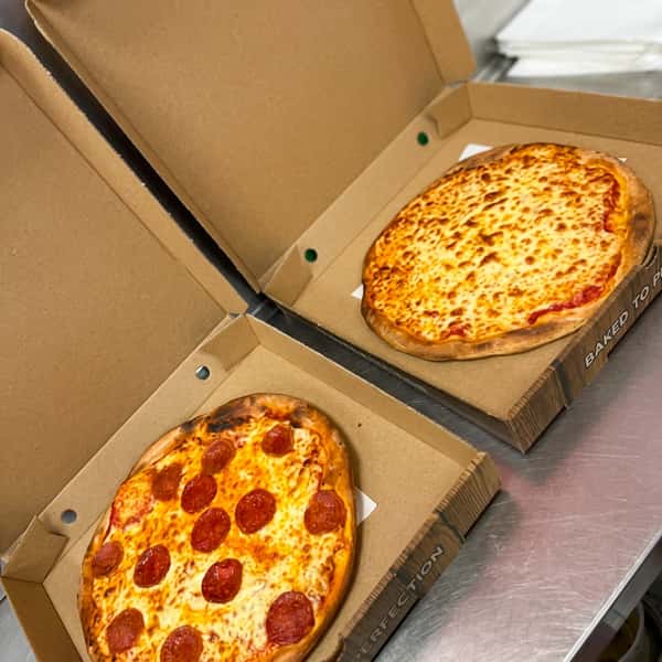 Pepperoni pizza and classic cheese pizza freshly baked and served in takeaway boxes