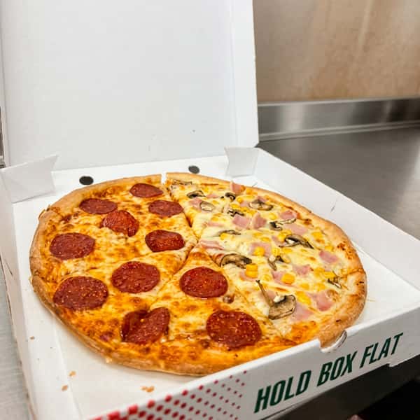 Half-and-half pizza topped with pepperoni, ham, mushrooms, sweetcorn, and melted cheese