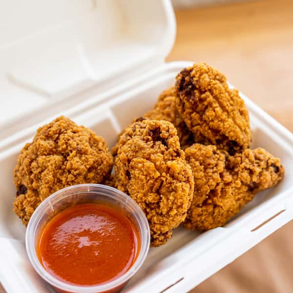 Crispy fried chicken pieces served with a spicy red dipping sauce