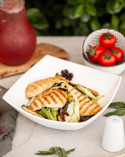 caesar salad with grilled chicken fillet slices