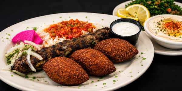 Lebanese combination plate with falafel, kibbeh, rice, hummus, salad, and sauces