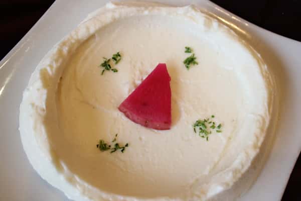 Creamy hummus topped with pickled turnips and parsley.