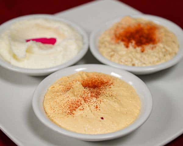 Lebanese trio featuring hummus and traditional creamy dips topped with spices