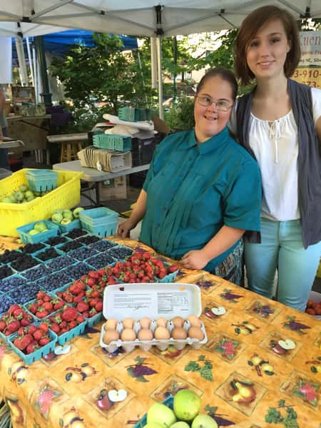 two women standing by fresh produce