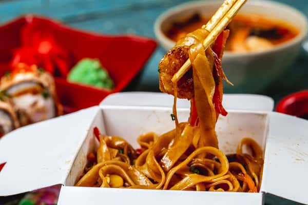 Stir fry noodles in a plate eaten with chopsticks