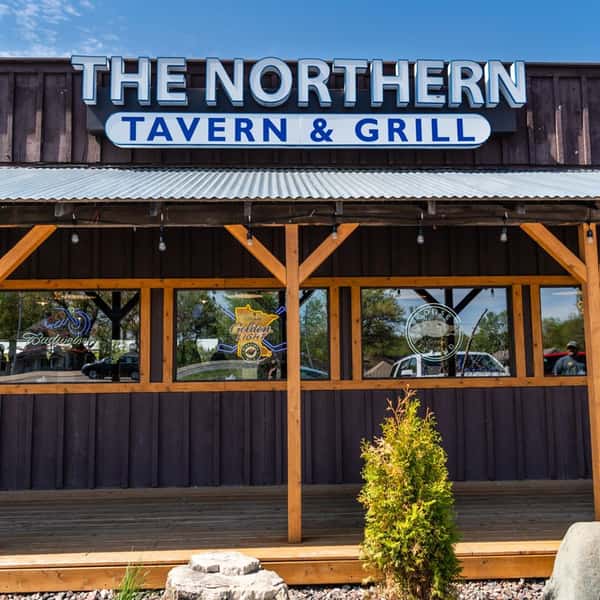 The exterior front entrance with a sign that reads "The Northern Lake Tavern & Grill"