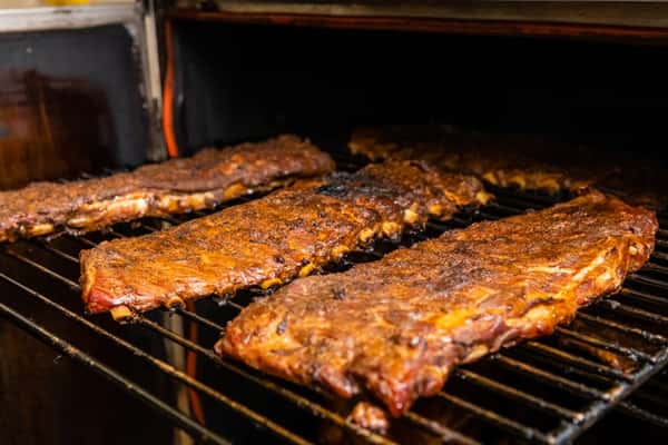 A rack of ribs cooking on the grill
