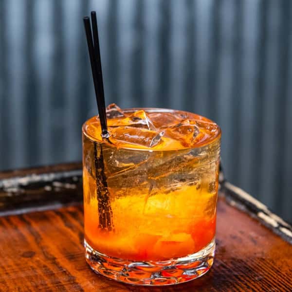 A cocktail in a glass on the bar countertop