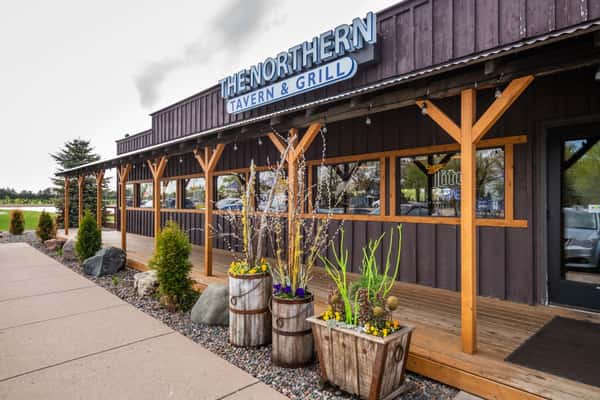 The exterior front entrance with a sign that reads "The Northern Lake Tavern & Grill"