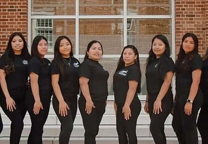 Thanks for sharing the image! This appears to be a group photo of a team or staff members, all dressed in coordinated black outfits, possibly representing a business or organization. If you need help creating a caption, promotional material, or identifying specific elements, feel free to let me know!