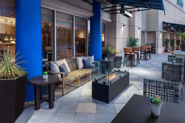Patio area with chairs, couches and a fireplace