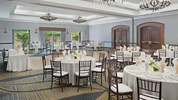 Event space filled with decorated tables and chairs for a wedding