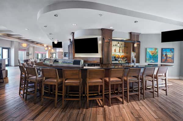Bar area with a rounded counter with bar stools and tv