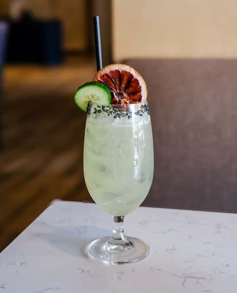 Cocktail with a citrus and cucumber slice