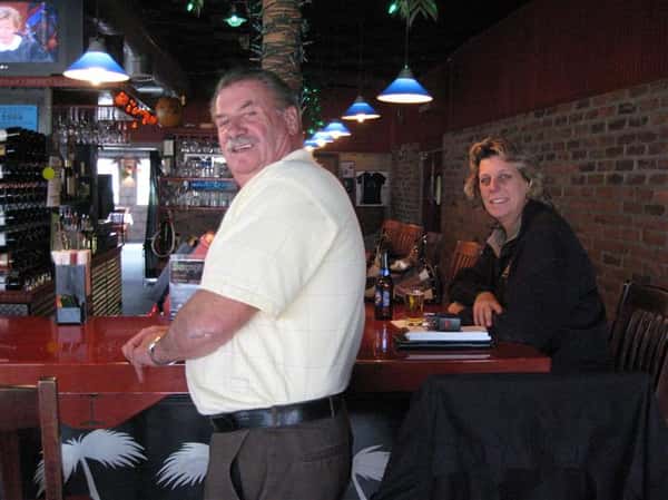 woman sitting at table, man standing next to table
