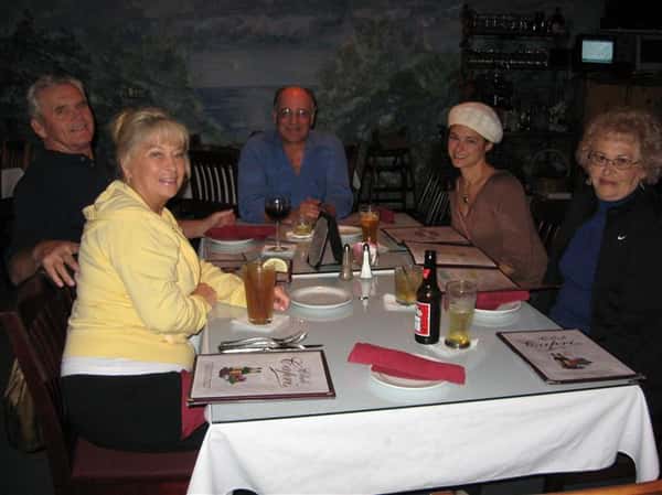three people sitting at a table smiling for picture