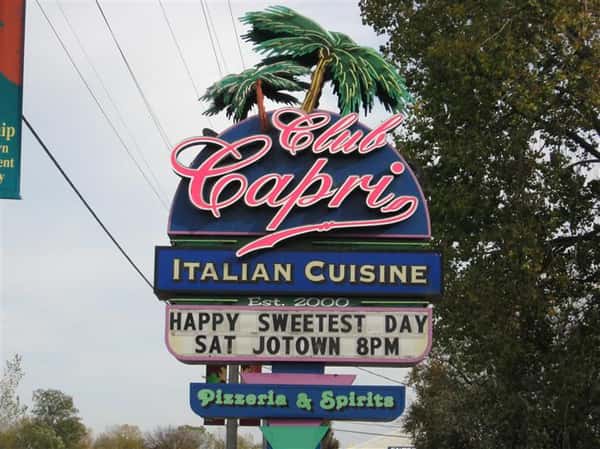 sign outside restaurant that reads club capri italian cuisine happy sweetest day sat jotown 8 pm pizzeria and spirits