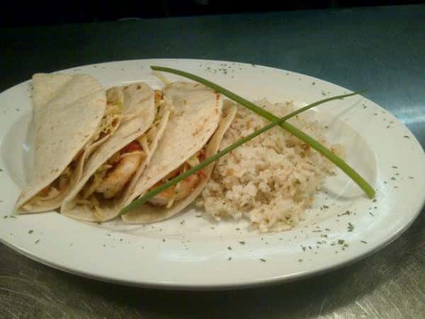 shrimp in taco shells with rice on the side