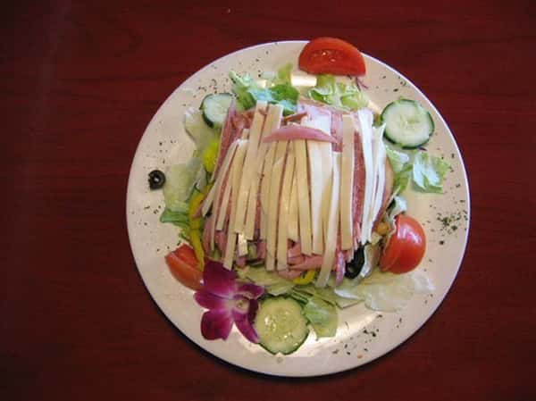 salad topped with slices of cheese and ham