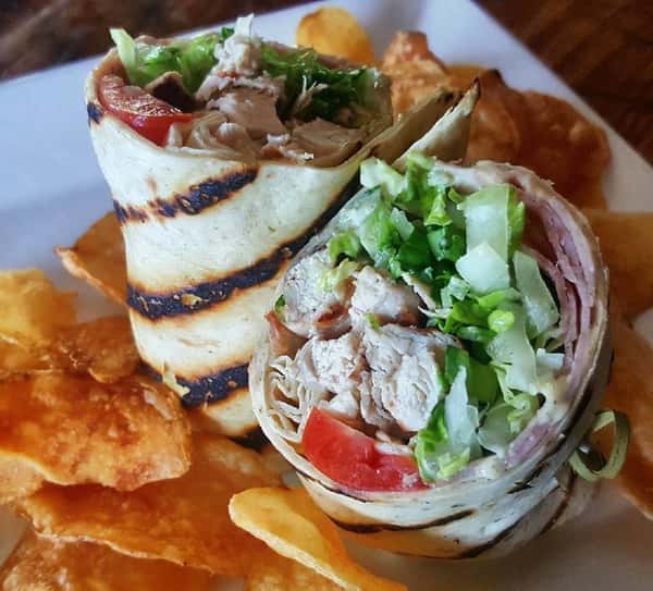 chicken wrap with lettuce, tomatoes and a side of chips