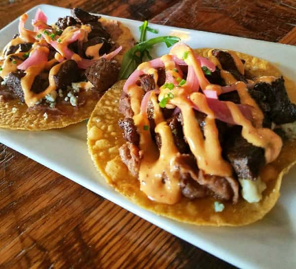 two large tacos with steak, vegetables and sauce