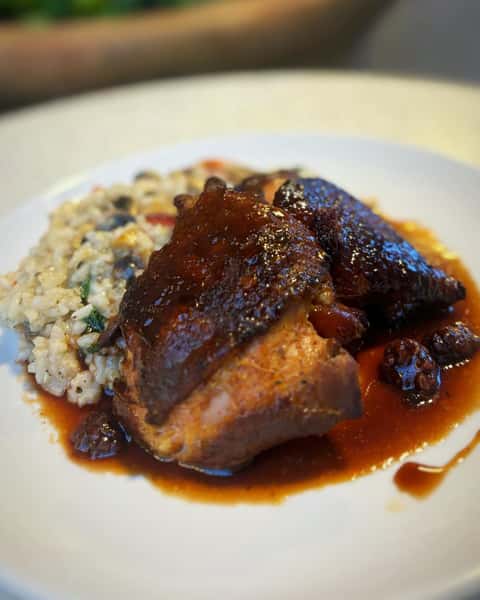 risotto features smoked chicken thighs, spinach, button mushrooms, and cherry heirloom tomatoes, all finished with a blackberry demi-glaze