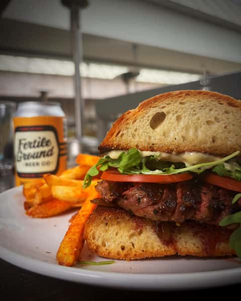 seared skirt steak on ciabatta with garlic mayo, caramelized onions, arugula, and tomatoes, served with blackened bleu fries