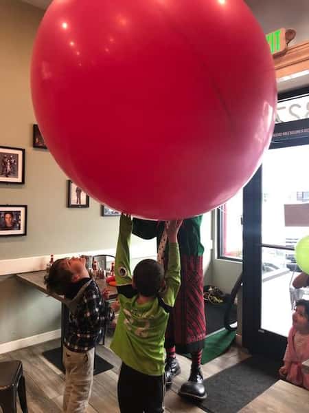 children playing with a clown and balloons