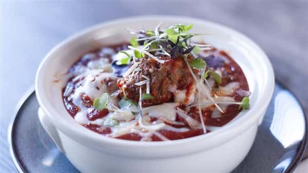 bowl of meatballs with sauce and mozzarella cheese
