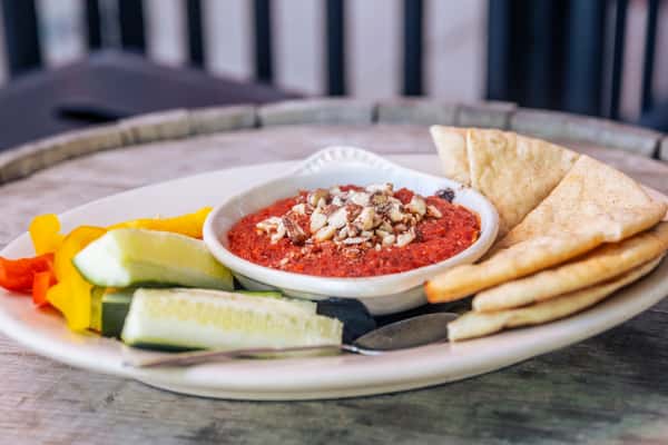 Photo of Nutty Goat Dip, plated with pita and veggies and topped with almonds. Photo Credit: The Bacyard.