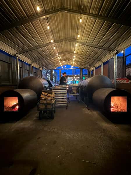 Wood-fired offset smokers in the Outsider BBQ pit house at night, Fremont, Seattle