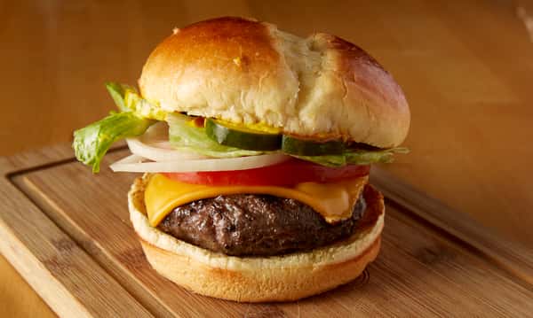 Burger with cheese, lettuce, onions and tomato