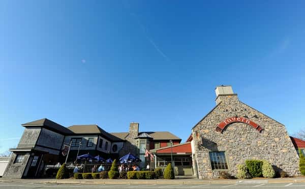 Exterior of stone building with outdoor patio with bright blue sku