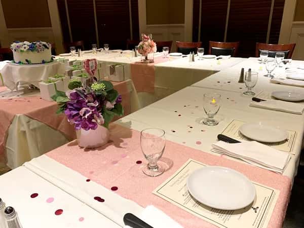 White table settings with pink cloth stripe and flowers