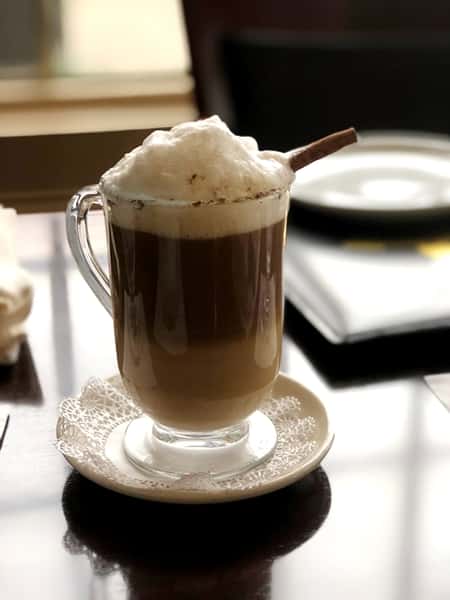Hot cappuccino with foam and cinimon stick