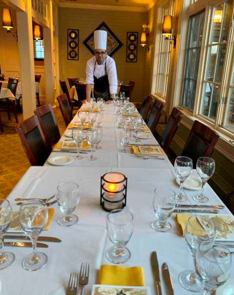 Catering table setting with yellow napkins with chef leaning on table