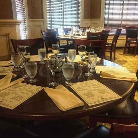 Catering table setting with yellow napkins on wooden table