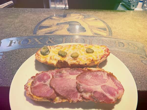 two pizzas one with cheese and pickles and one with me