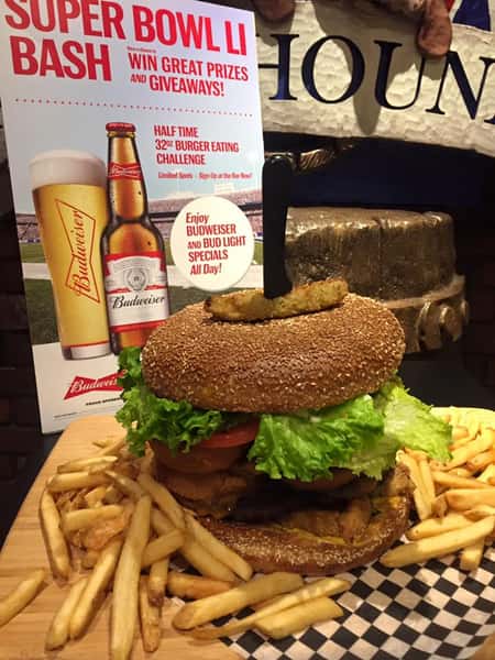 a large burger with lettuce and tomato and a side of fries